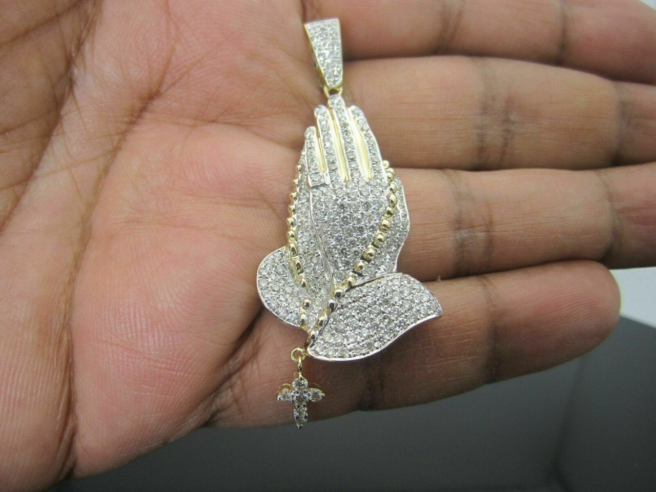 Close-up of 925 sterling silver praying hands rosary pendant with CZ diamonds