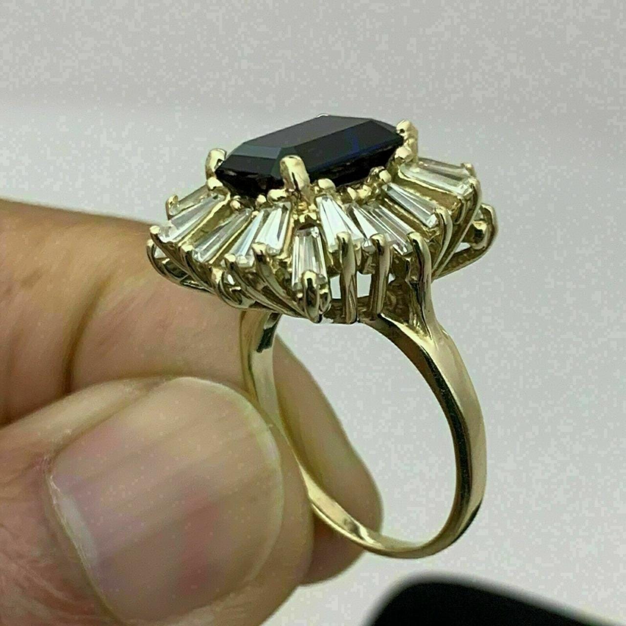 Exquisite 18K gold-finish ring featuring a striking emerald-cut blue CZ and sparkling simulated diamonds.&quot;