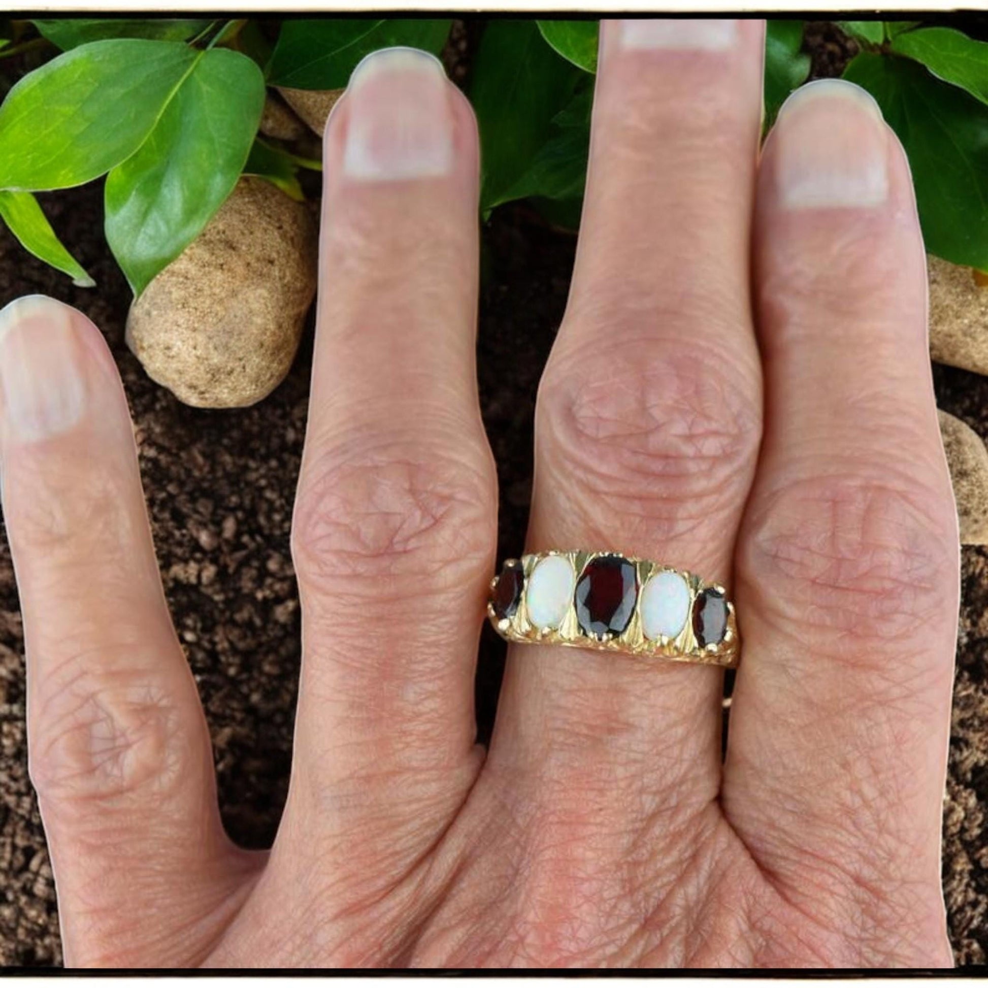 Elegant Edwardian ring with a deep red garnet and iridescent opal, crafted in 925 sterling silver with gold plating.